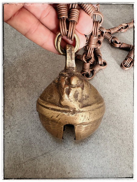 Antique brass bell on chain