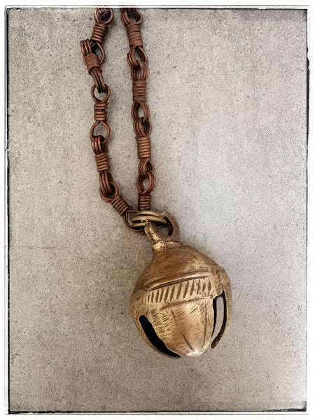 Antique brass bell on chain
